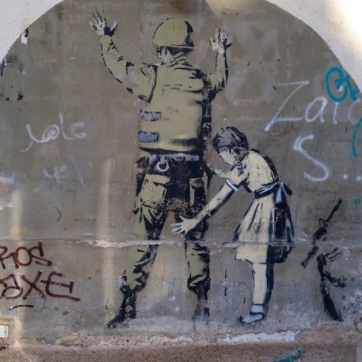 Girl frisks soldier - pic of graffiti by Dan Meyers via Unsplash