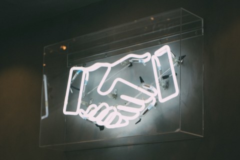 handshake neon sign photo by Charles Deluvio on Unsplash